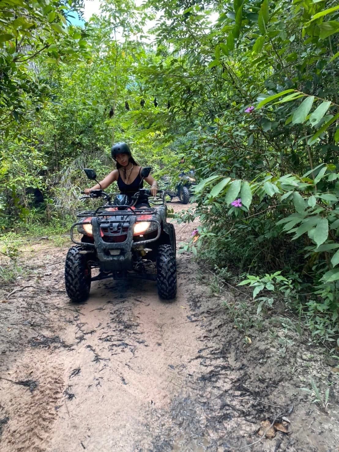Riding a quad along a muddy jungle track