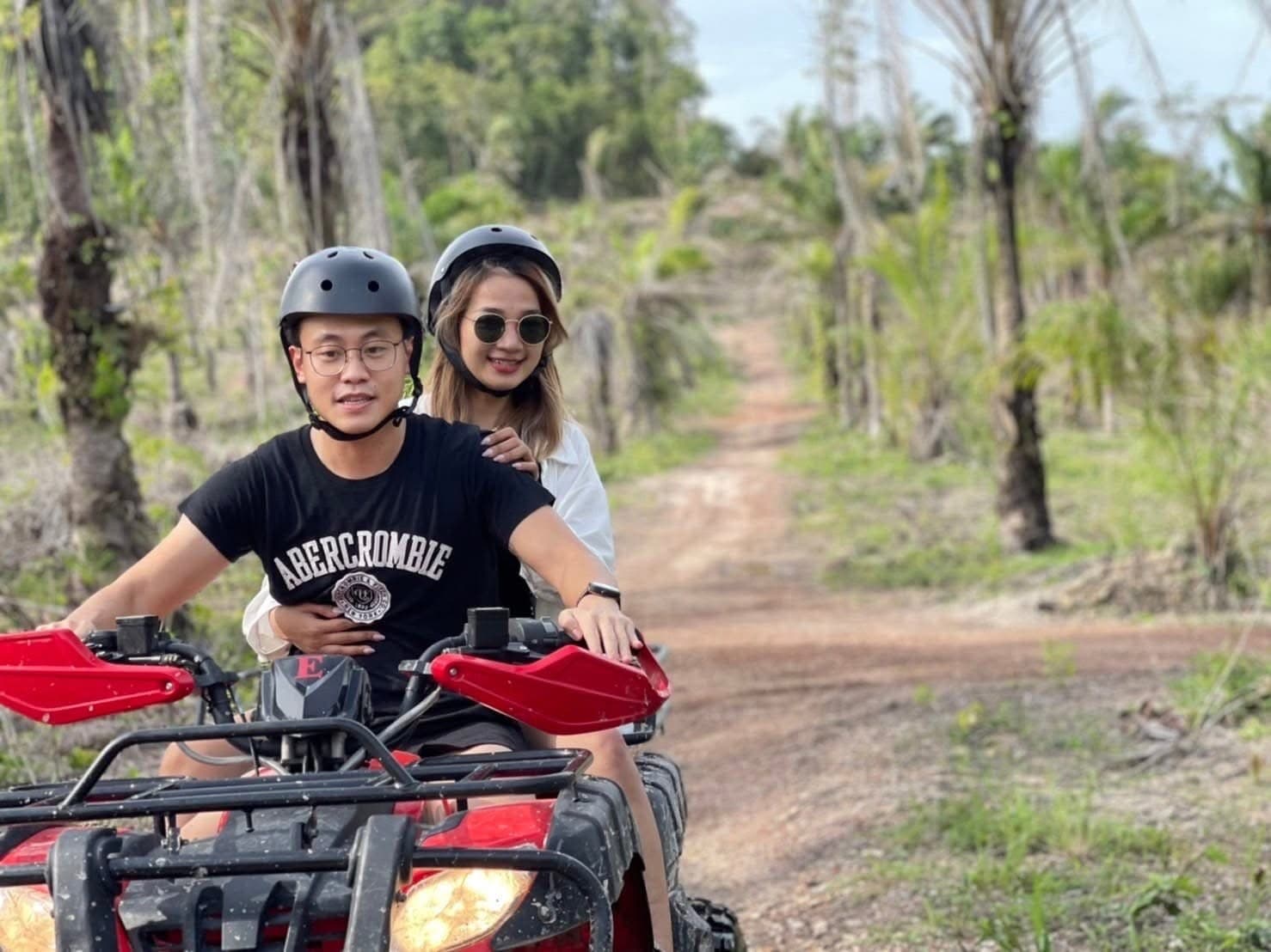 Driver and passenger on a quad through the plantation