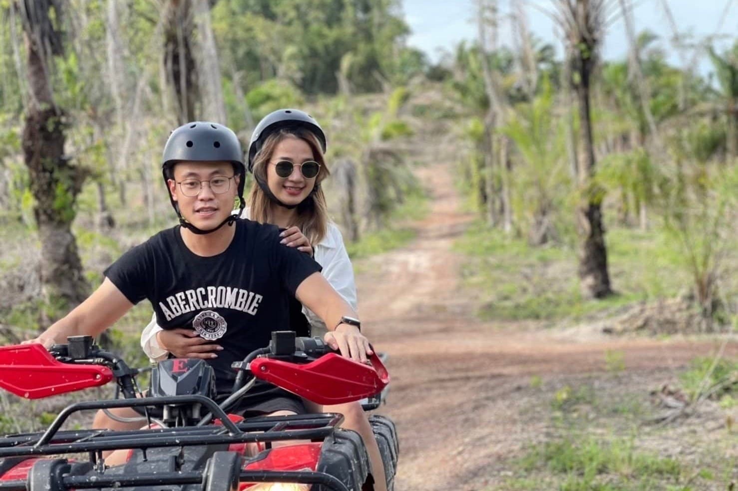 Driver and passenger on a quad through the plantation