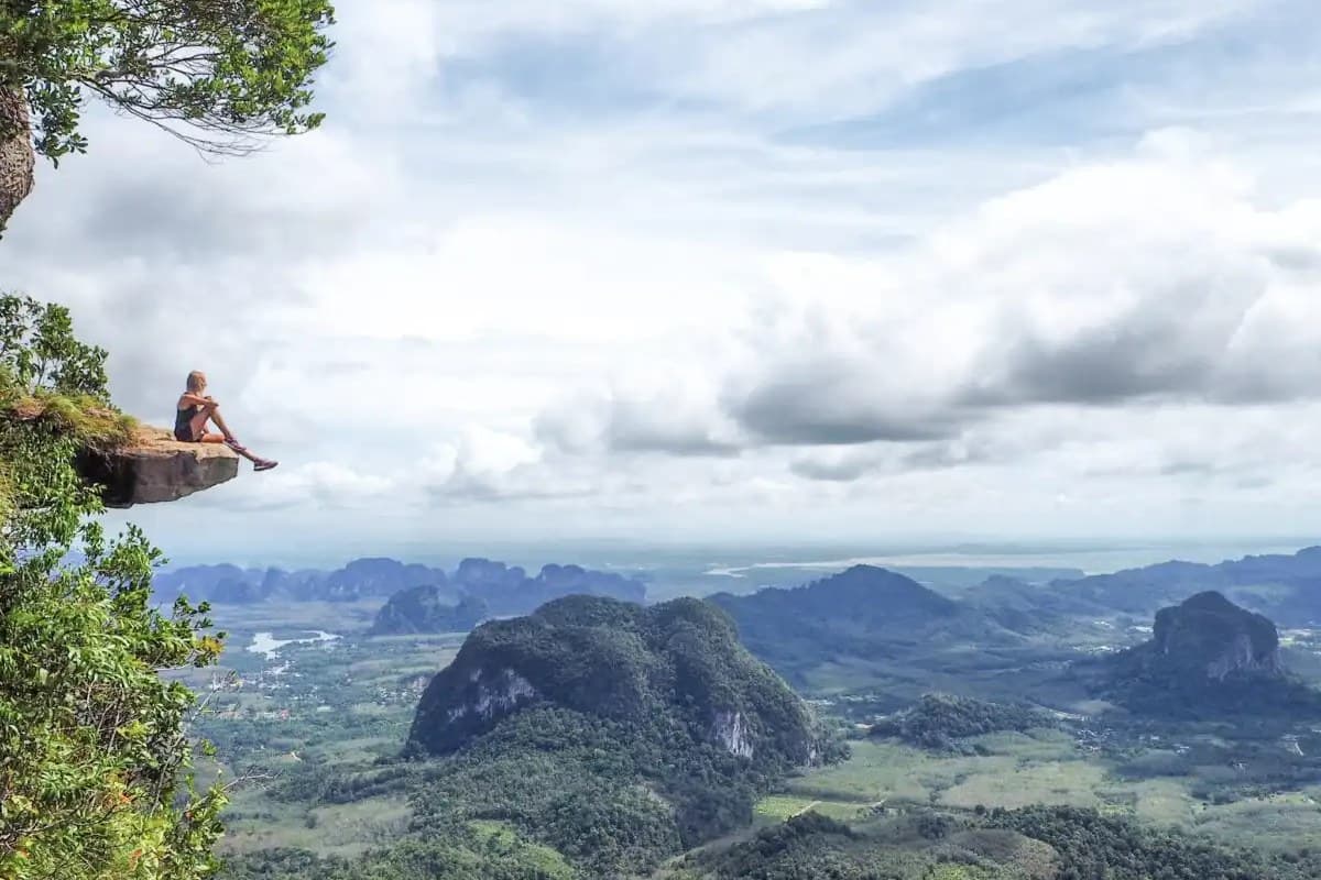 Sitting on the ledge at the Hang Nak summit, Krabi below