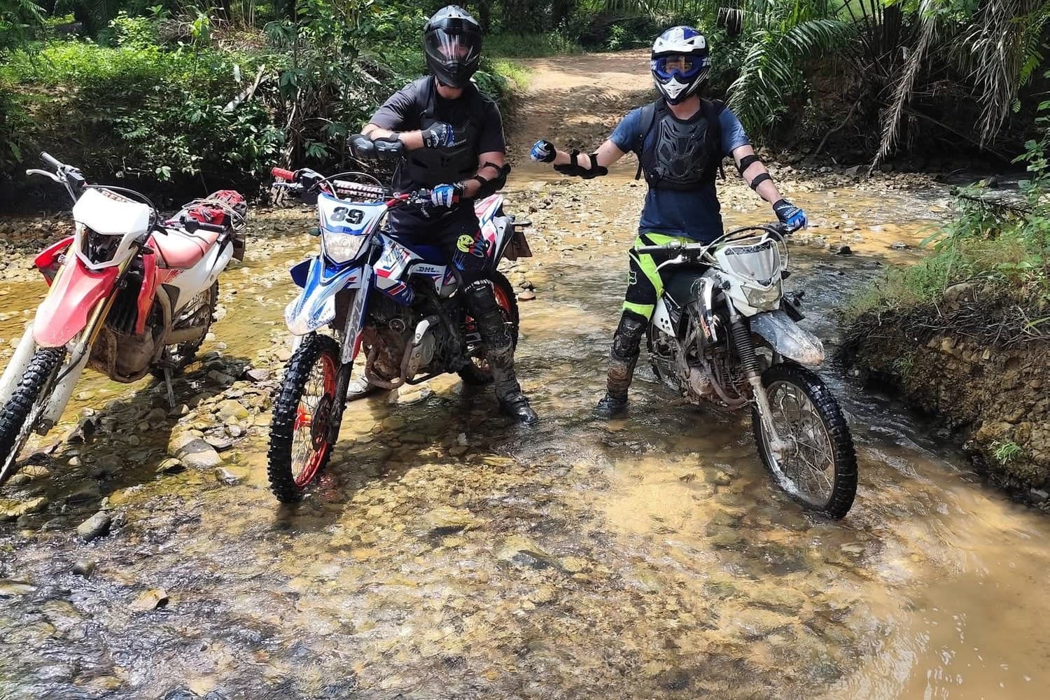 Two riders at a river crossing on the plantation trails