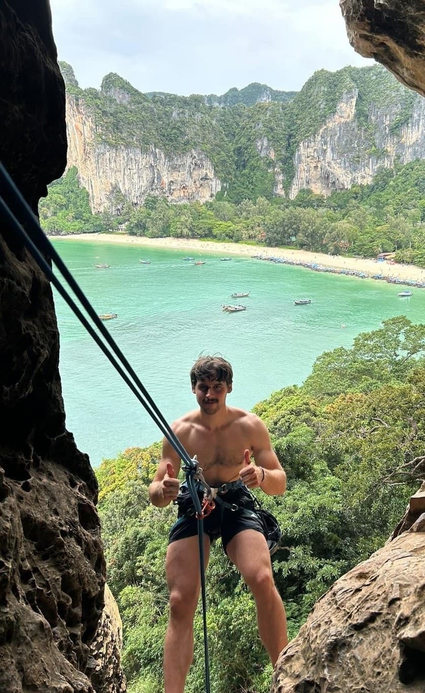 Abseiling from a cave with Railay beach below
